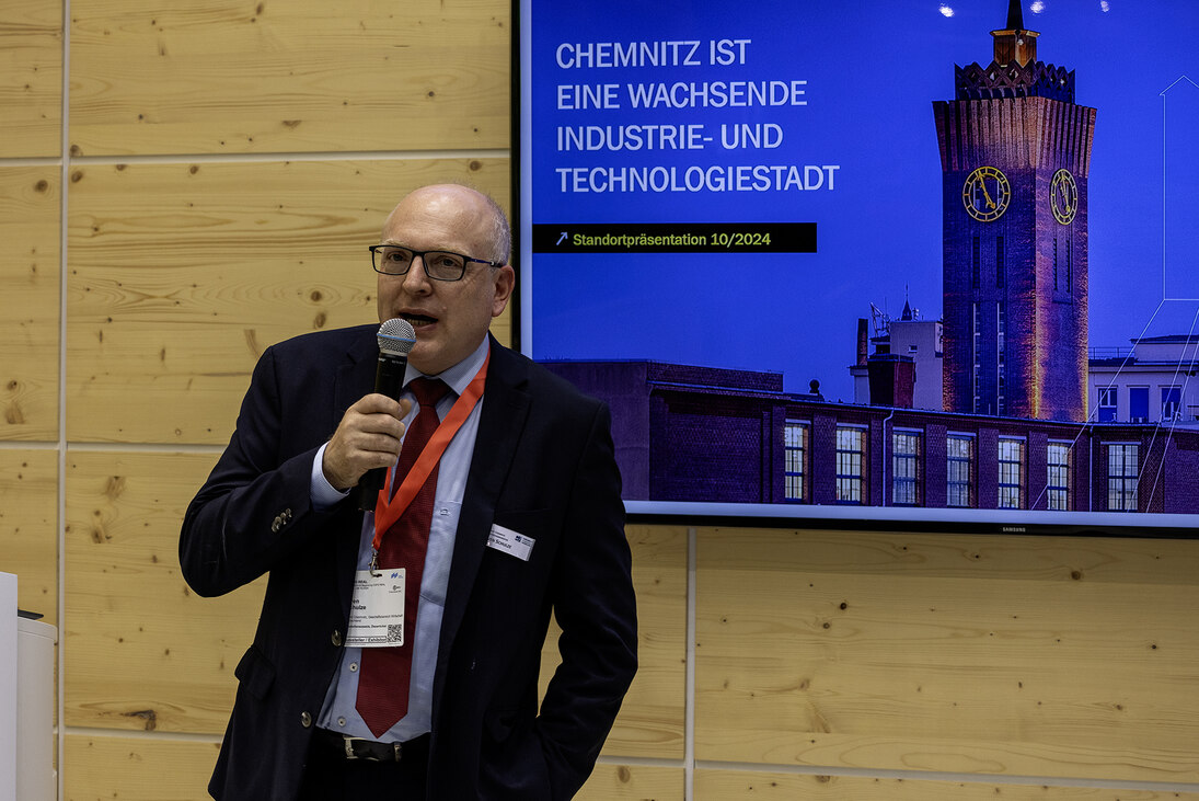 Mann mit Mikrofon spricht zu Publikum