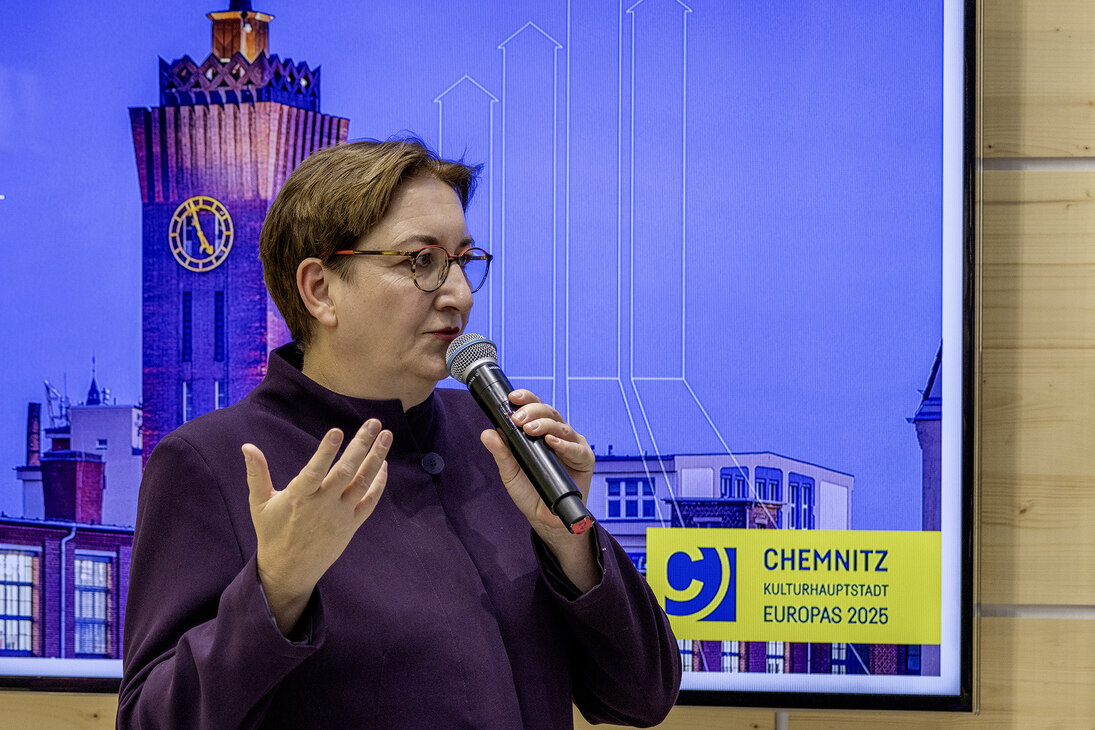 Frau mit Mikrofon hält Vortrag