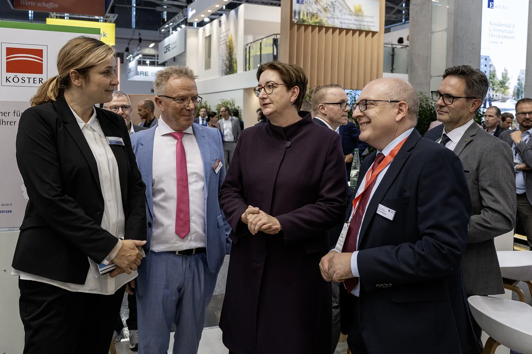 Vier Personen stehen nebeneinander und unterhalten sich.