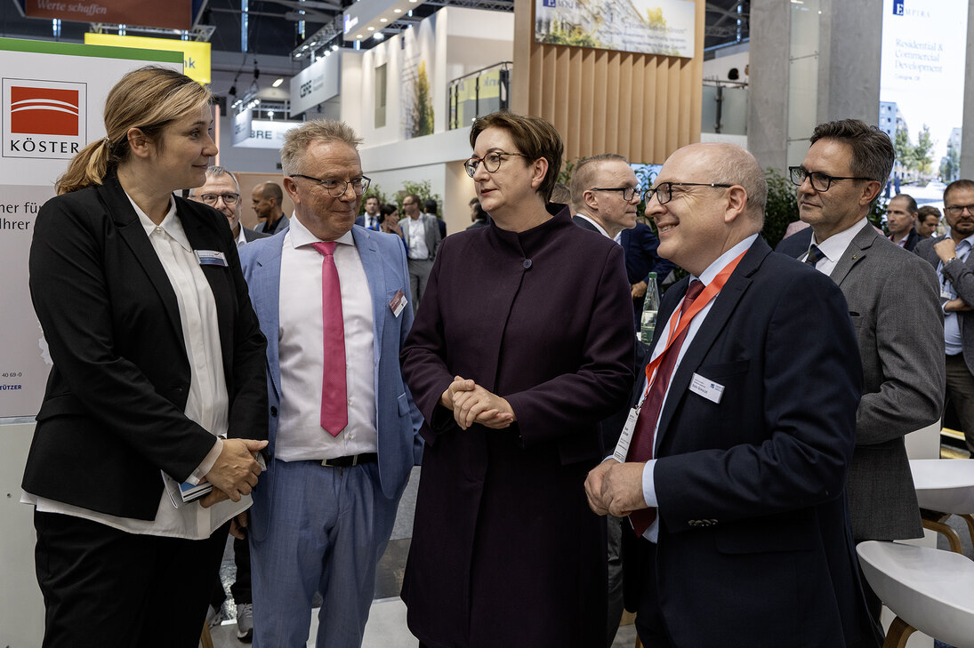 Vier Personen stehen nebeneinander und unterhalten sich.